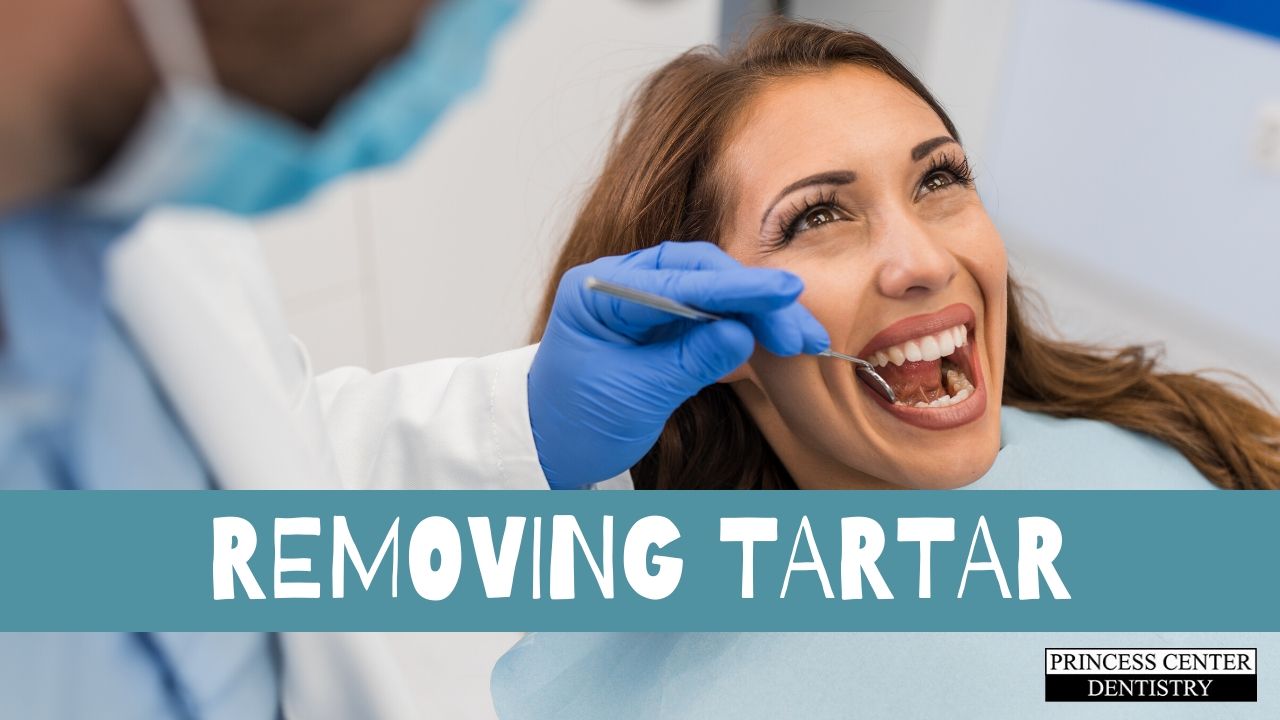 A hygienist removes tartar from a patient's teeth