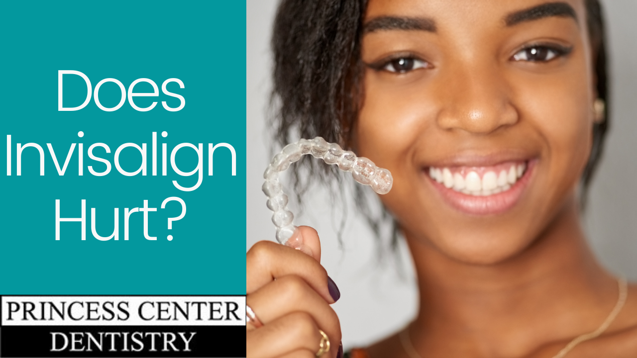 African American woman smiling and holding an Invisalign tray